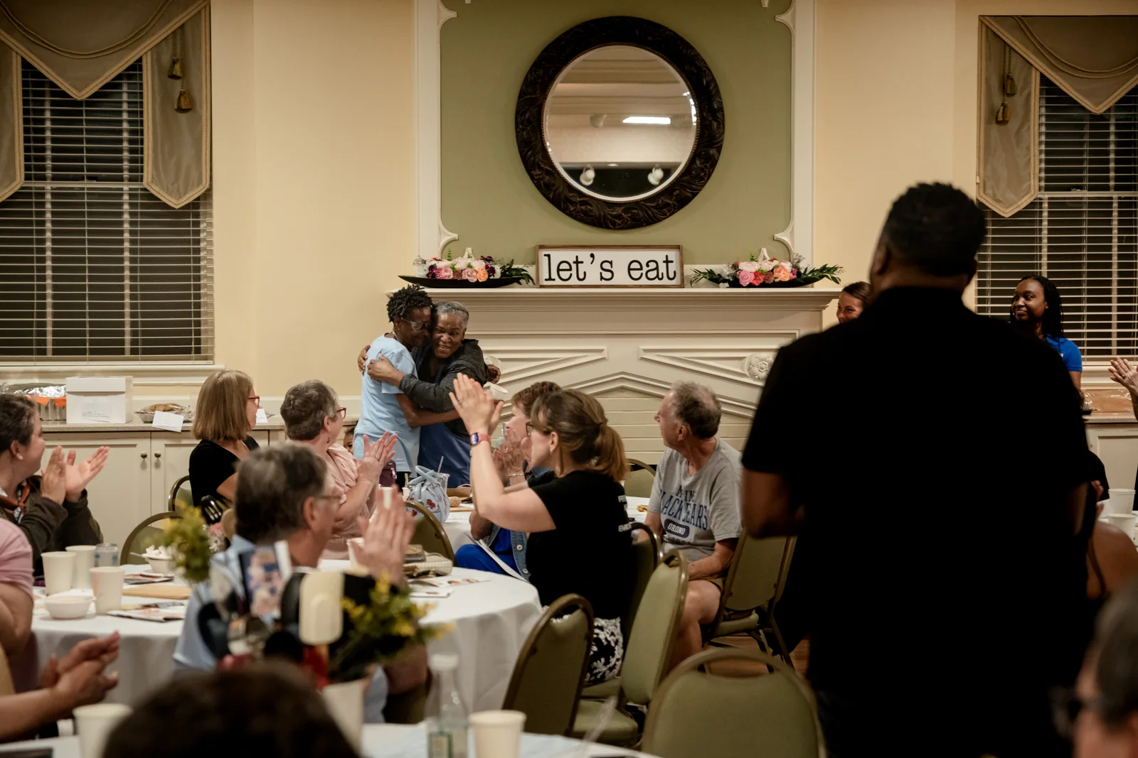 Community members gather around tables at the Bake-Off